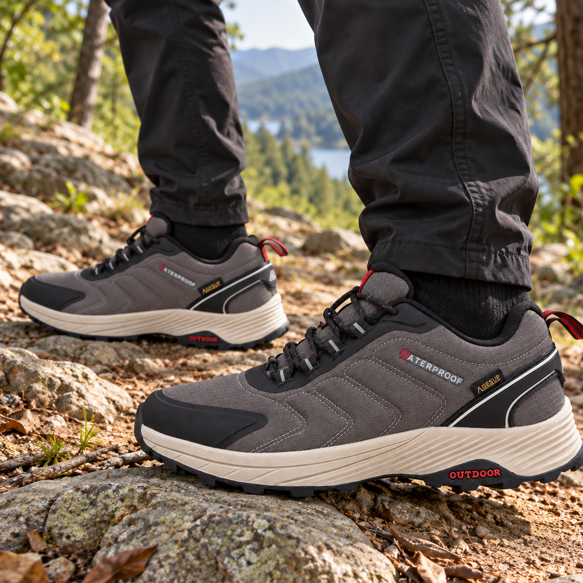 Paire de chaussures randonnée synthétiques grises portée sur un sentier rocheux