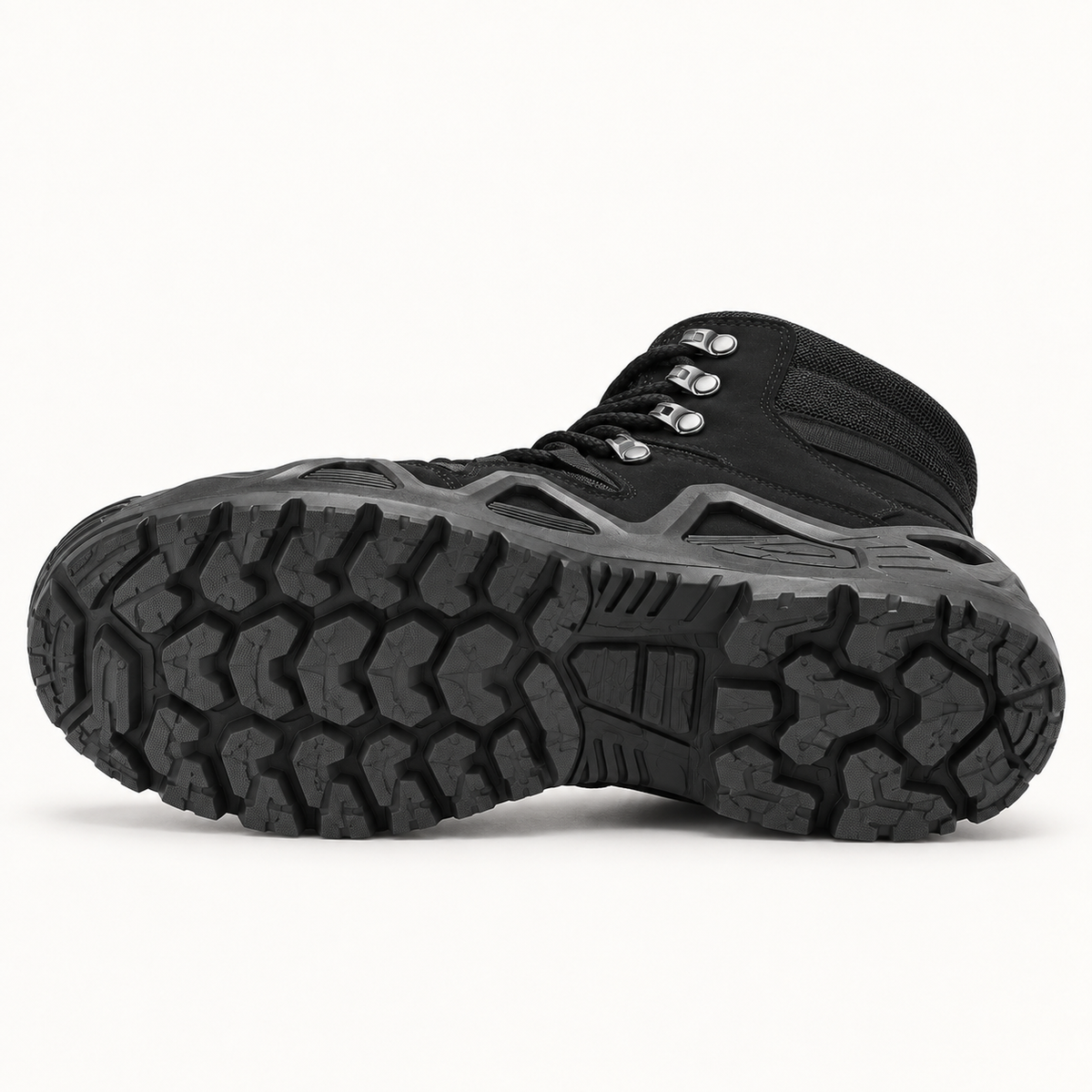 Chaussure randonnée montante noire couchée sur le côté montrant toute la semelle attachée