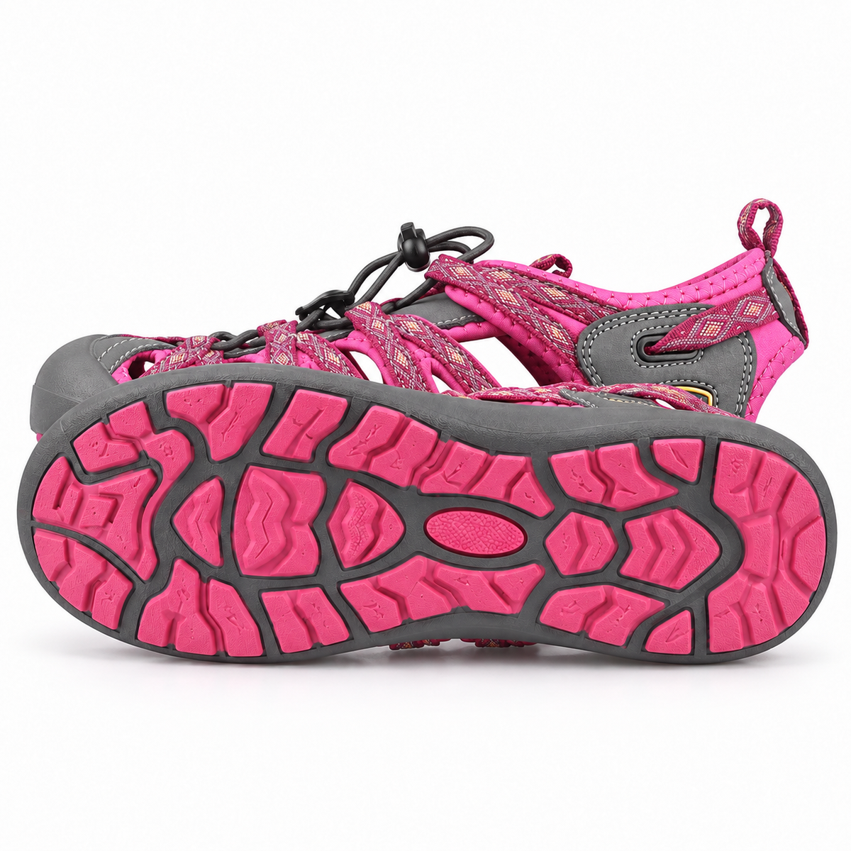 Sandale femme plate de randonnée rose couchée sur le côté avec semelle entière visible