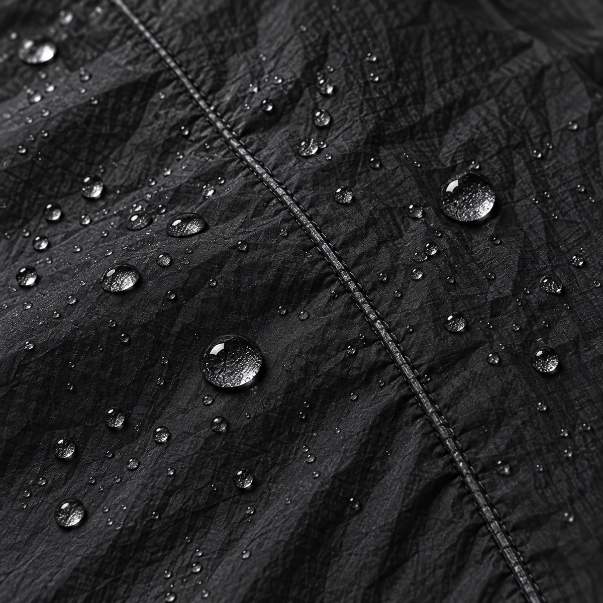 Gouttes d'eau perlées sur la matière noire de veste imperméable respirante