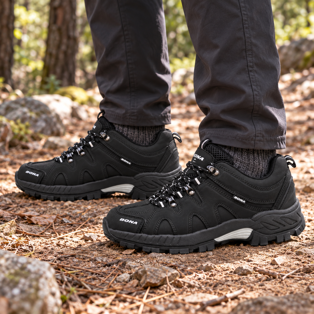 Paire de chaussures randonnée femme noires portée sur un sentier