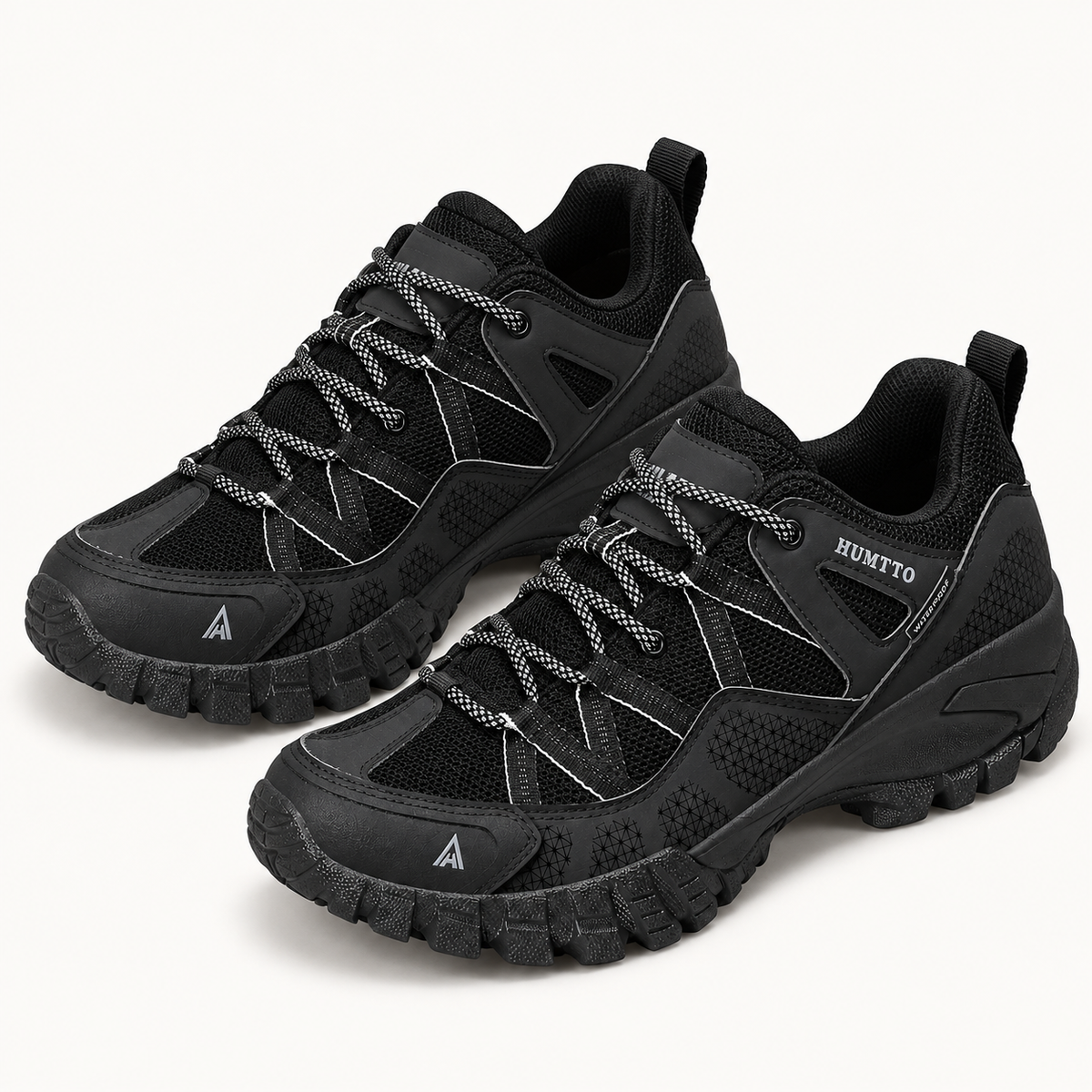 Paire complète de chaussures randonnée noires basses sur fond blanc chaud