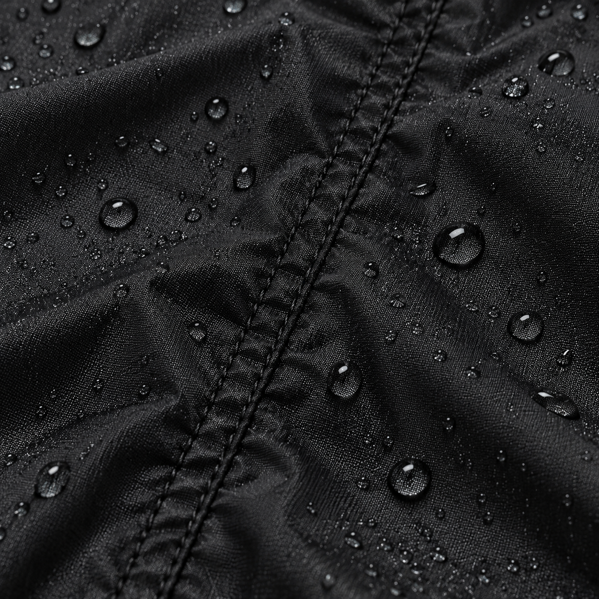 Macro de la matière noire de veste pluie randonnée avec couture et gouttes d'eau