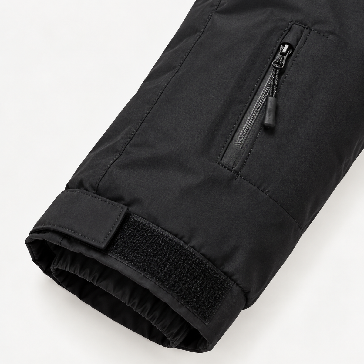 Veste randonnée haute montagne noire – détail poignet réglable et poche de manche